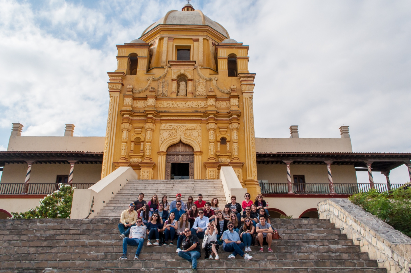 Student group poses in front of building.