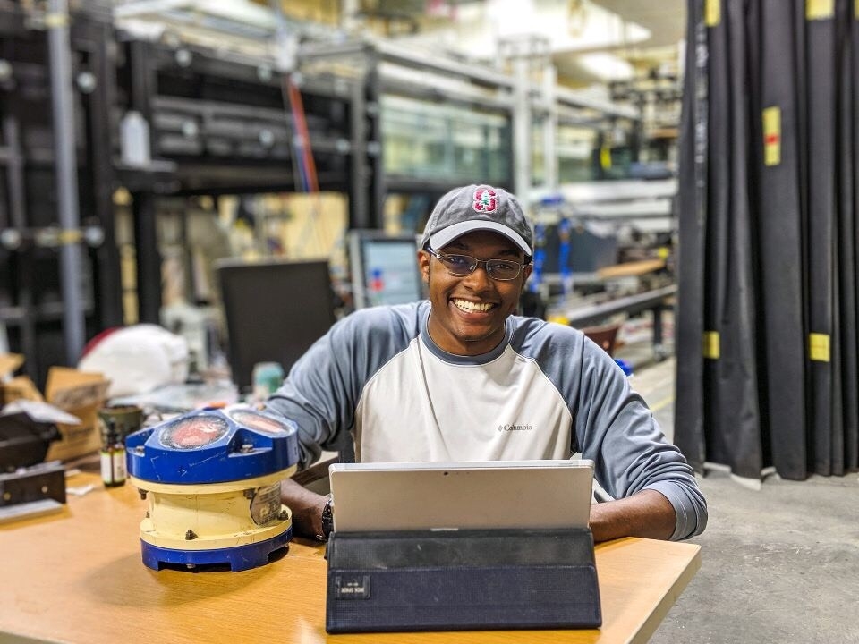 Student sitting at work station with a laptop and other equipment