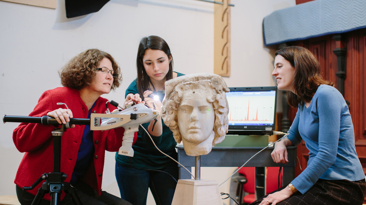 Professor and students looking at Greek sculpture
