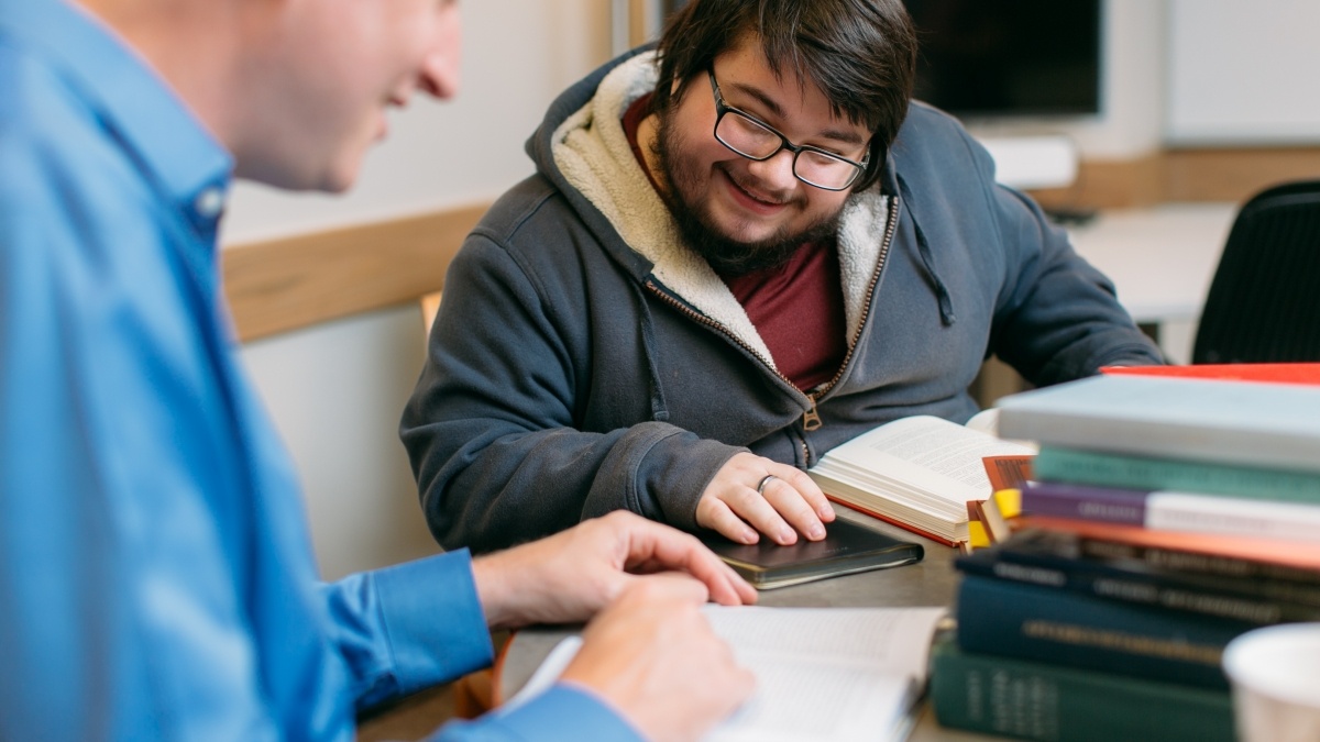 Student and professor discussing a book