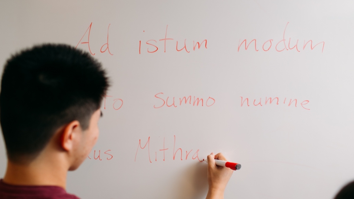 A student writes on a whiteboard