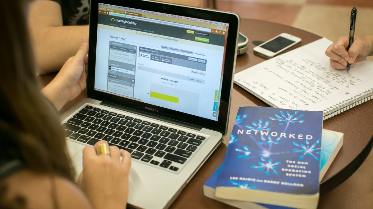 Student at a laptop with a couple literature books on the table