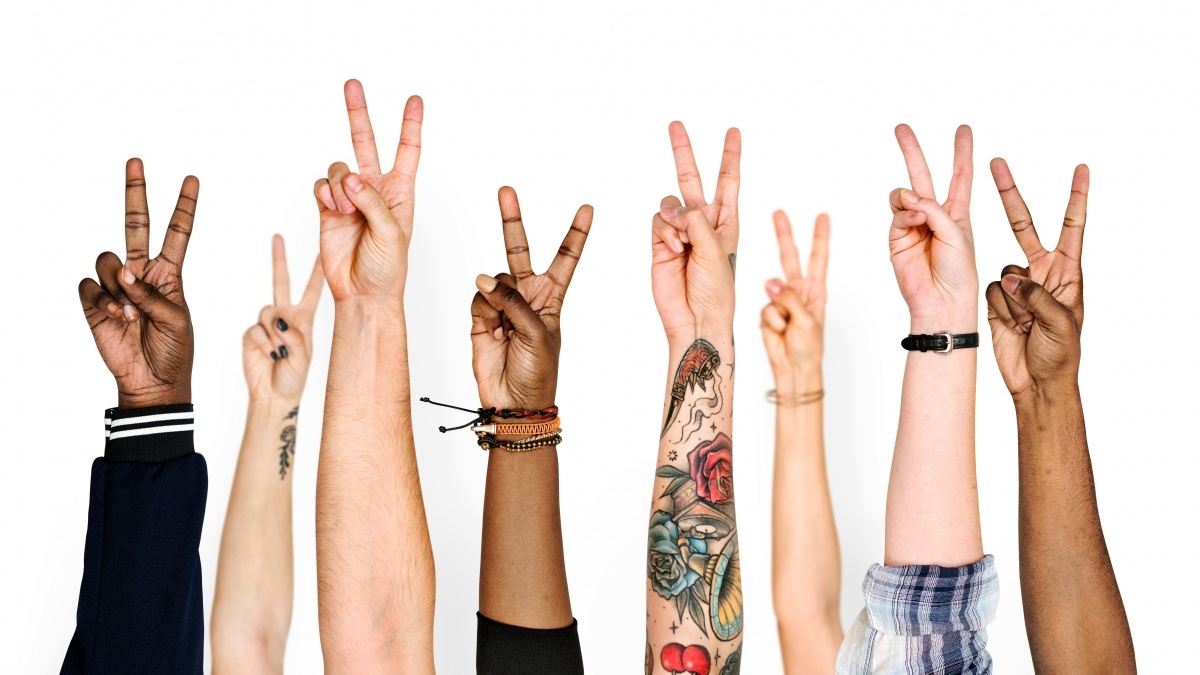 various arms raised giving peace sign