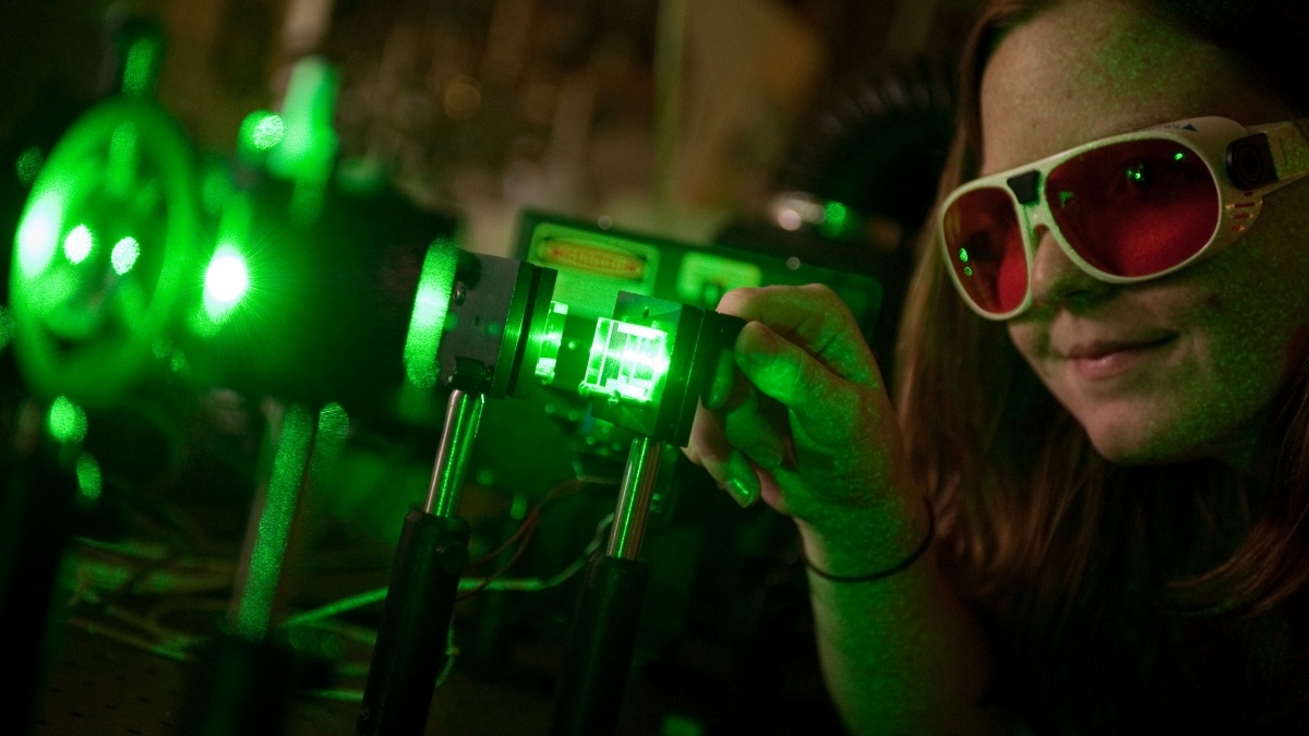 Student with protective glass in photonics lab