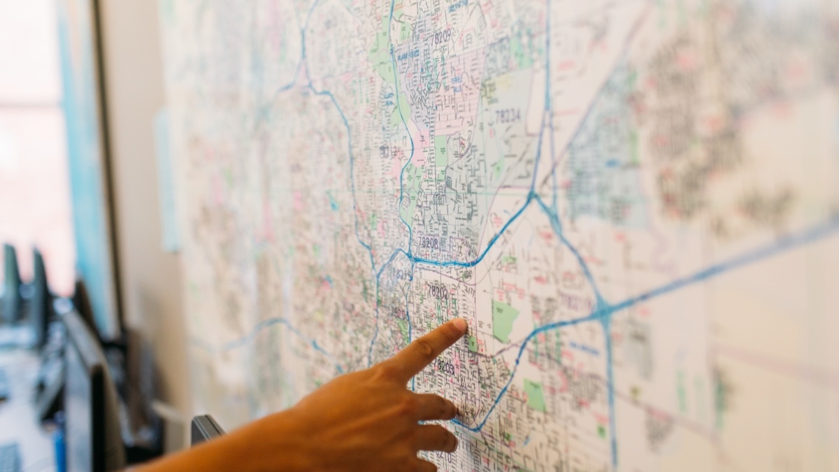 Hand pointing at a map