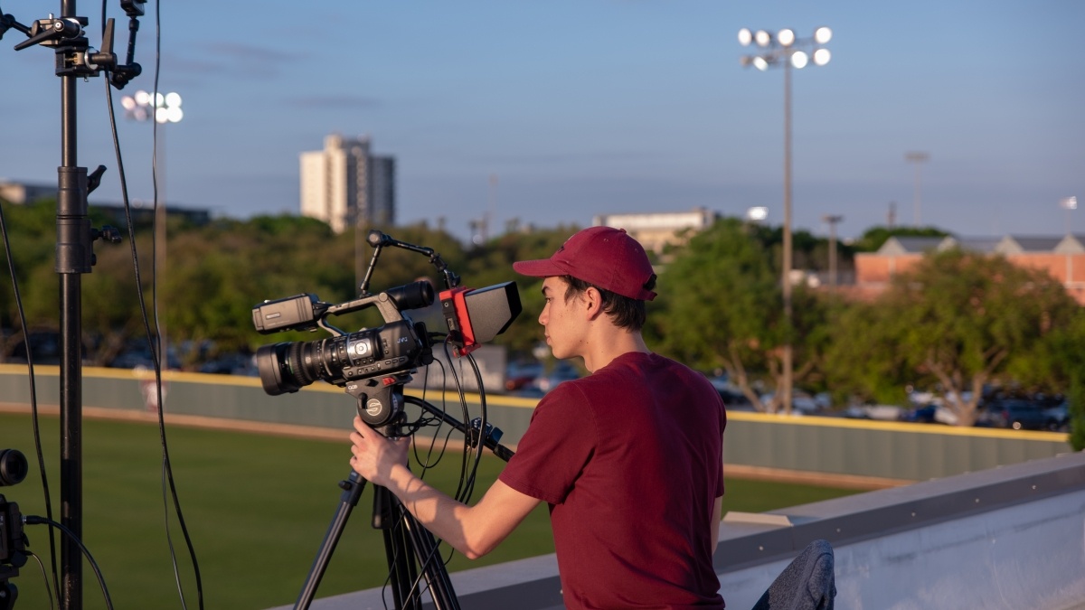 A student films an event on Trinity's campus