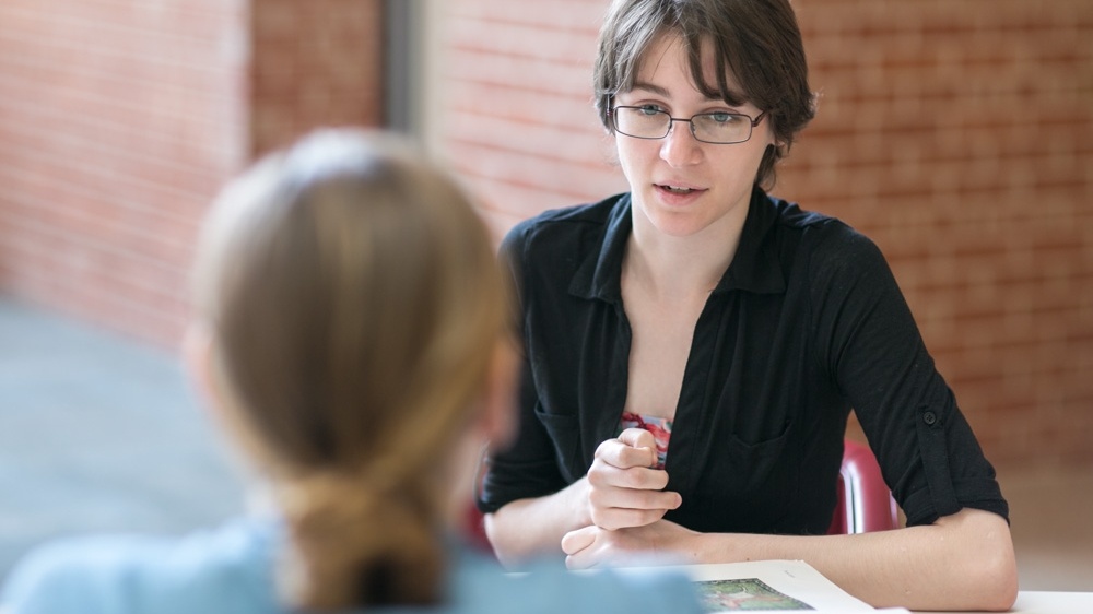 two people talking across a desk